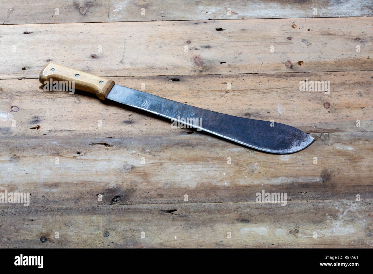 Eine Machete auf einer hölzernen Hintergrund Stockfoto