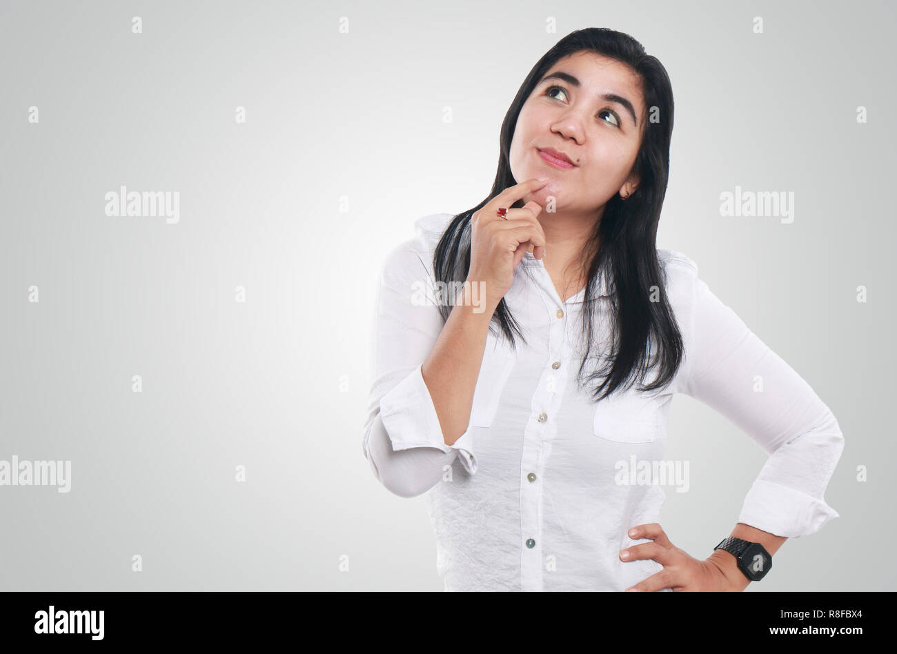 Foto Bild Portrait einer netten jungen asiatischen Geschäftsfrau, Lächeln, während an etwas denken, Kontemplation Geste Stockfoto