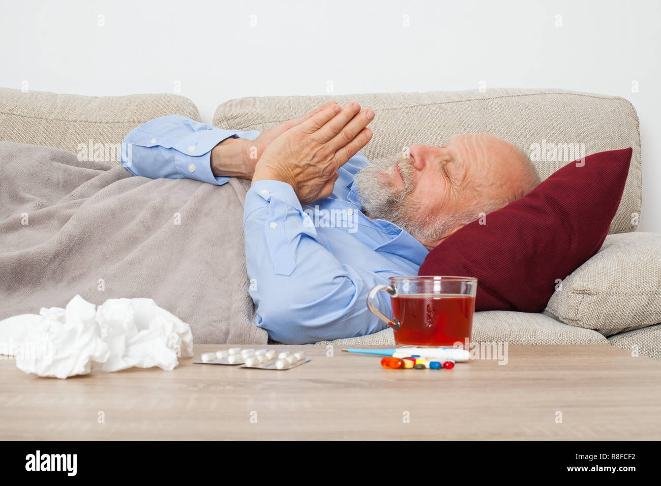 Ältere männliche Patienten auf der Couch liegen zu Hause krank Stockfoto