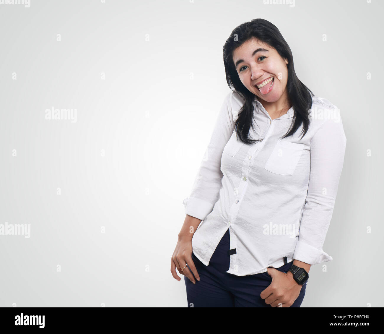 Foto Bild Portrait einer schönen netten jungen asiatischen Geschäftsfrau sah sehr aufgeregt und glücklich lachend mit beiden Hände auf ihre Taille, mit herausgestreckter Zunge Stockfoto