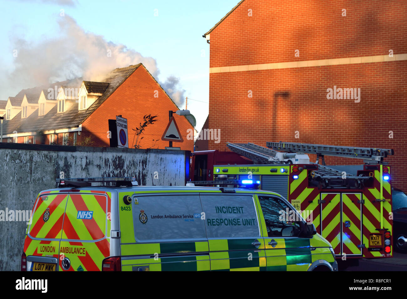 Emergency Services reagieren zu einem Haus Brand in einer Wohnstraße in East London mit einer Anzahl von Feuerwehrfahrzeugen einschließlich einer Antenne Plattform Stockfoto