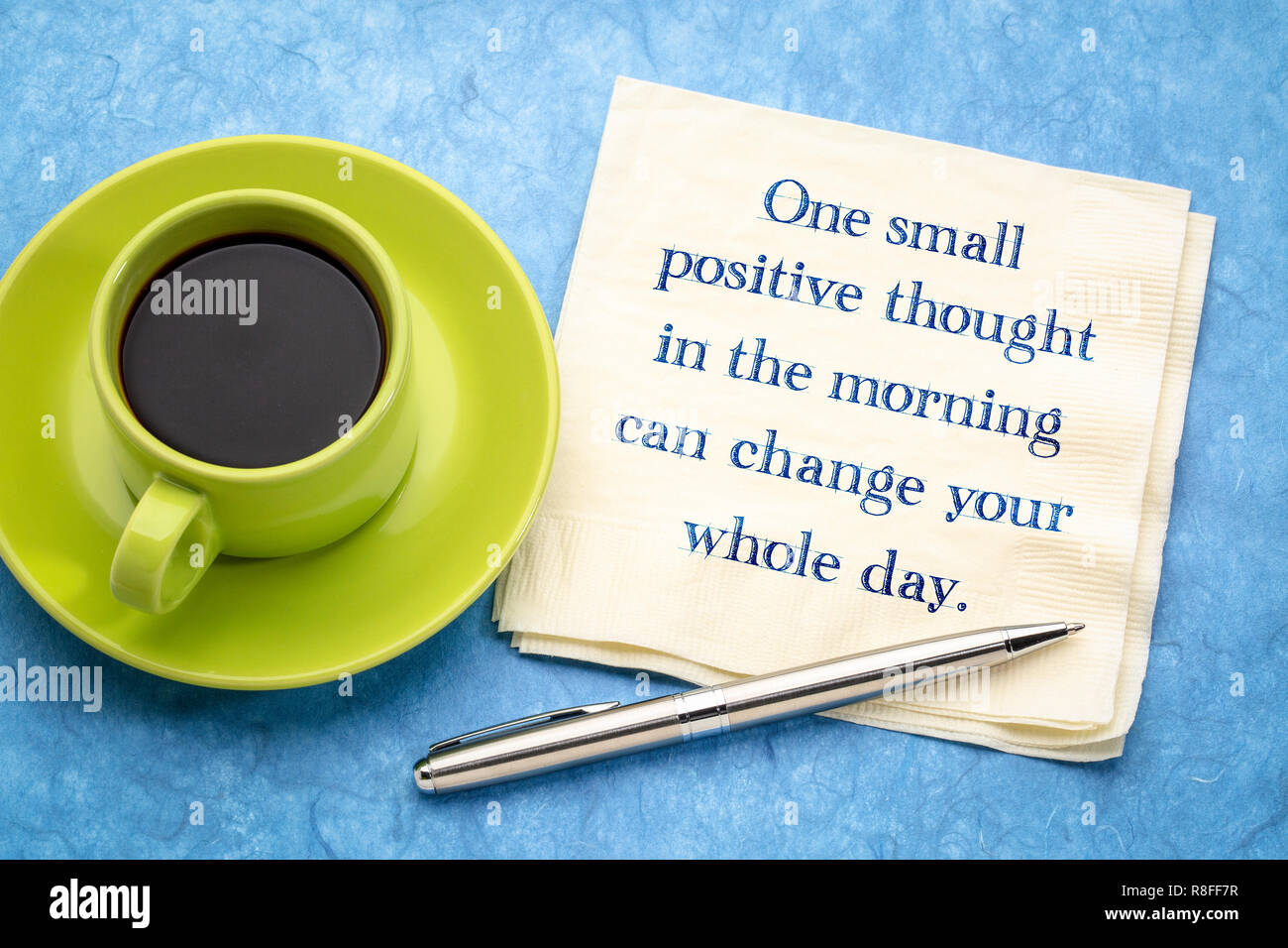 Eine kleine positive Gedanken am Morgen können Sie den ganzen Tag - inspirational Handschrift auf eine Serviette mit einer Tasse Kaffee Stockfoto