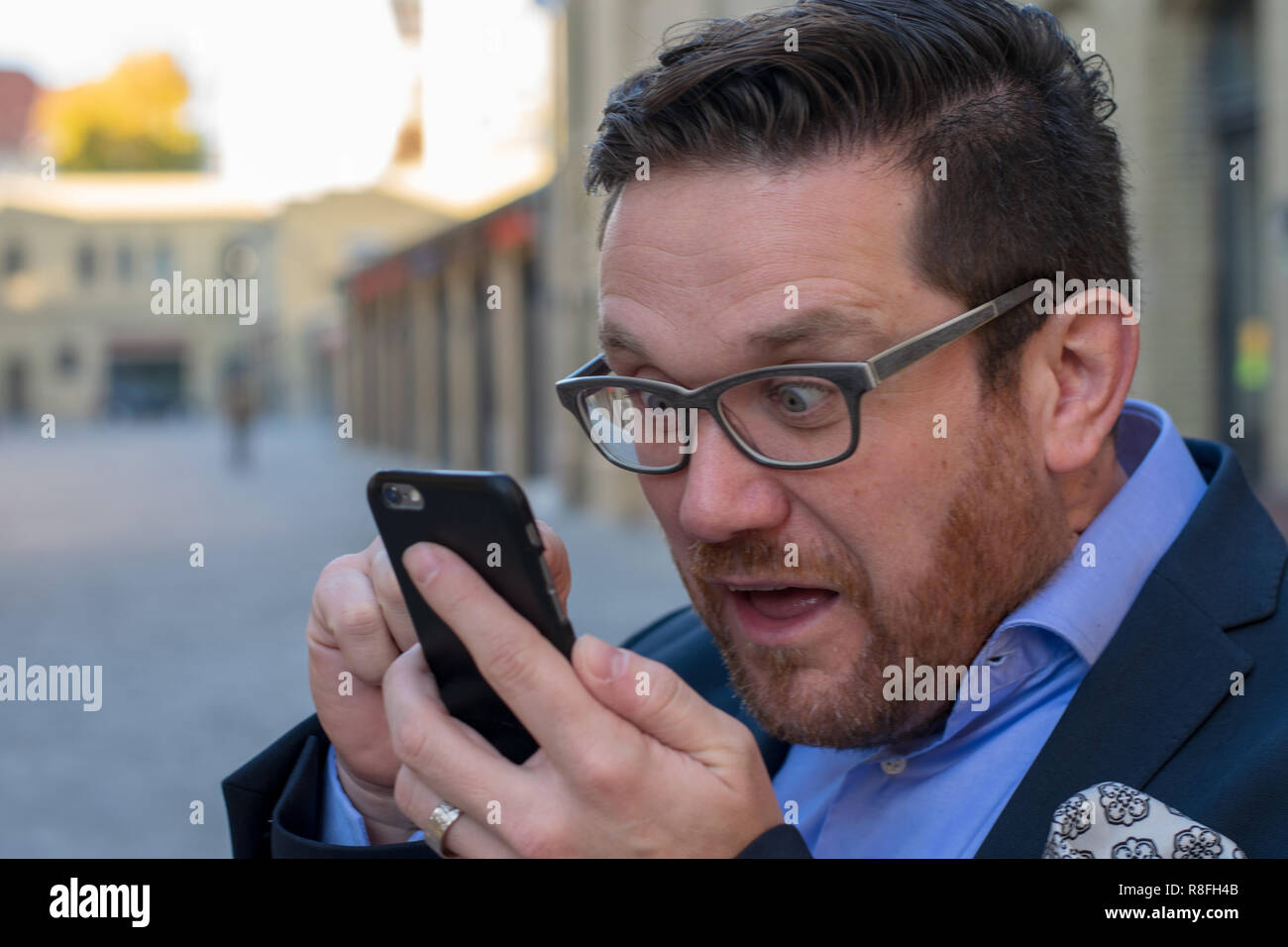 Crazy Business Mann durch Meldung auf mobile überrascht Stockfoto