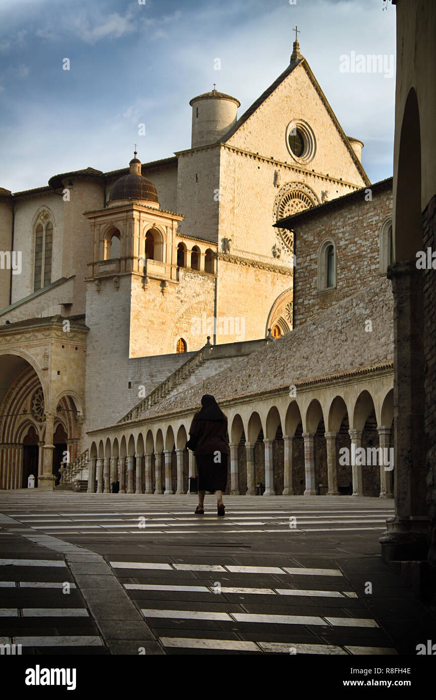 Eine Nonne, die zu Fuß zum Eingang des Heiligen Franz von Assisi Basilika. Stockfoto