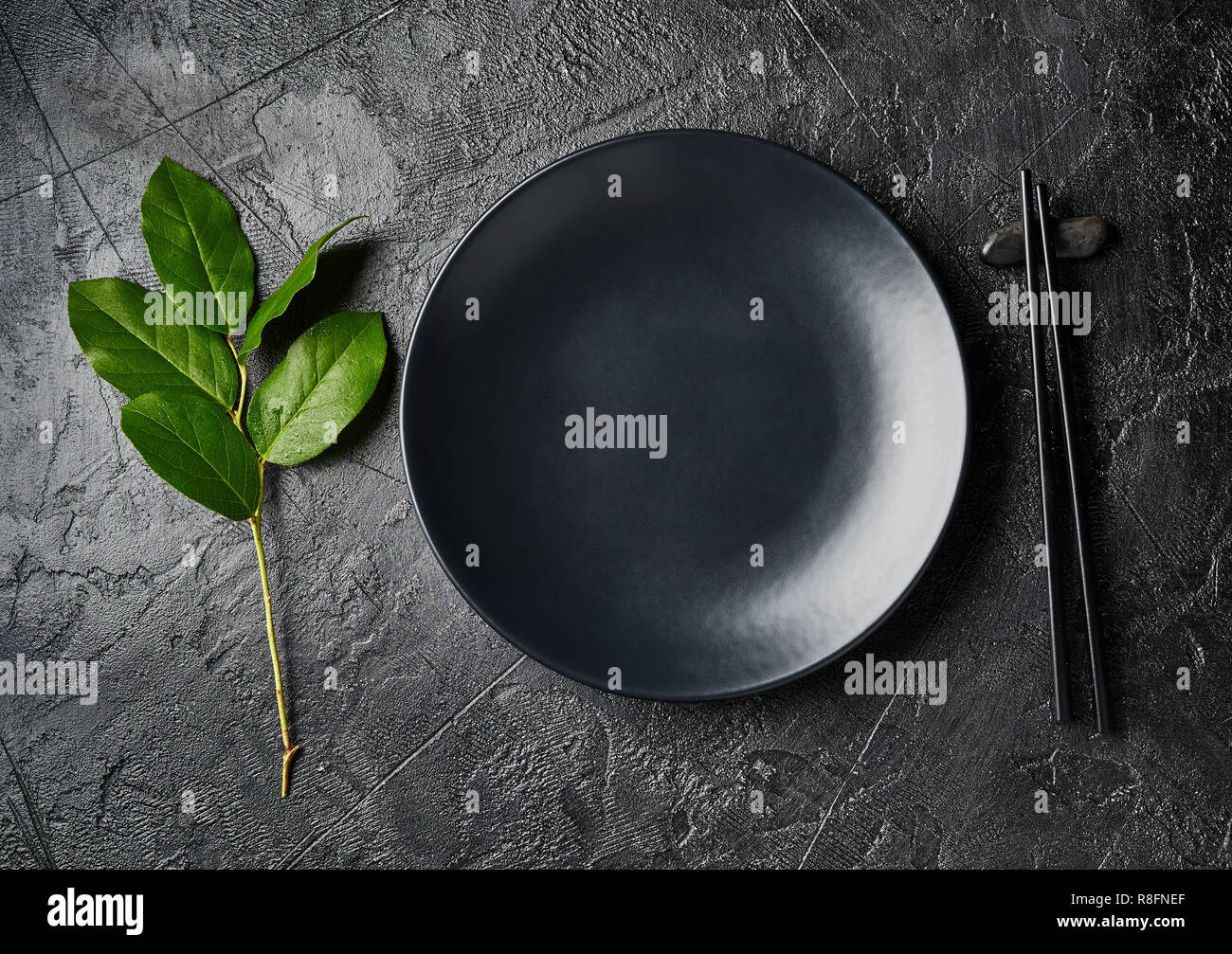 Dunkle leere Platte von asiatische Lebensmittel mit schwarzen Stäbchen auf schwarzem Schiefer. Im asiatischen Stil. Stockfoto