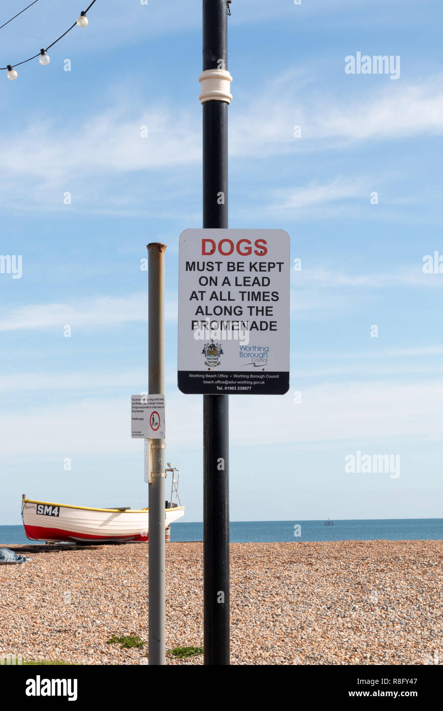 Schild am Strand, Hunde müssen an der Leine geführt werden. Stockfoto