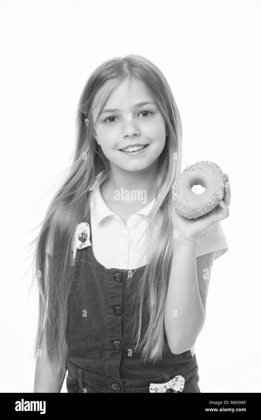 Kind Lächeln mit Donut isoliert auf Weiss. Kleines Mädchen mit glasierten ring Donut. Glückliches Kind mit Junk Food. Essen für Snacks und Dessert. Kindheit und Kinderbetreuung. Diät und Fitness Concept. Stockfoto