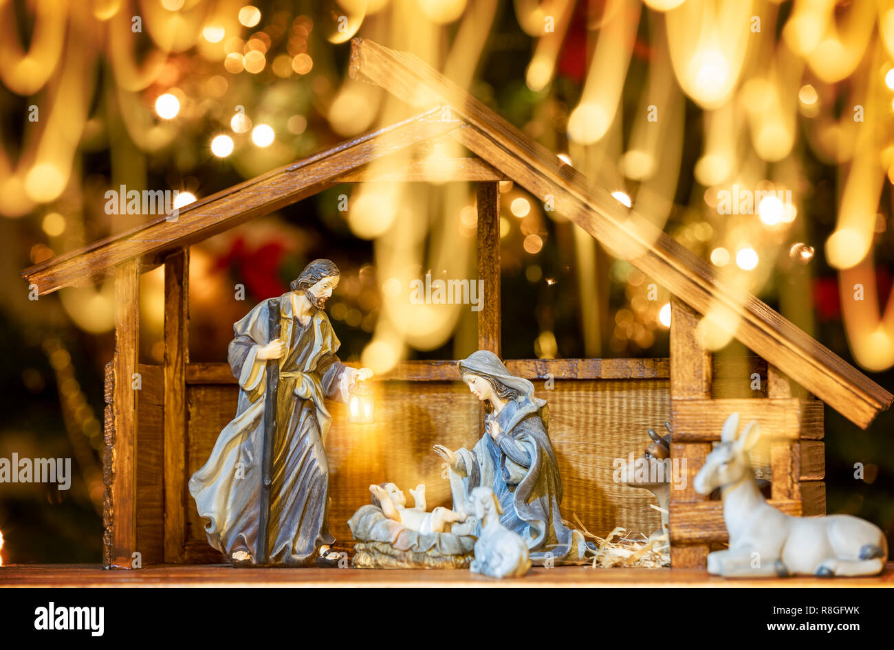 Weihnachten Krippe mit Figuren wie Jesus, Maria, Josef, Schafe und Weisen. Fokus auf Mutter! Lichter Zug vor der Fotokamera. Stockfoto