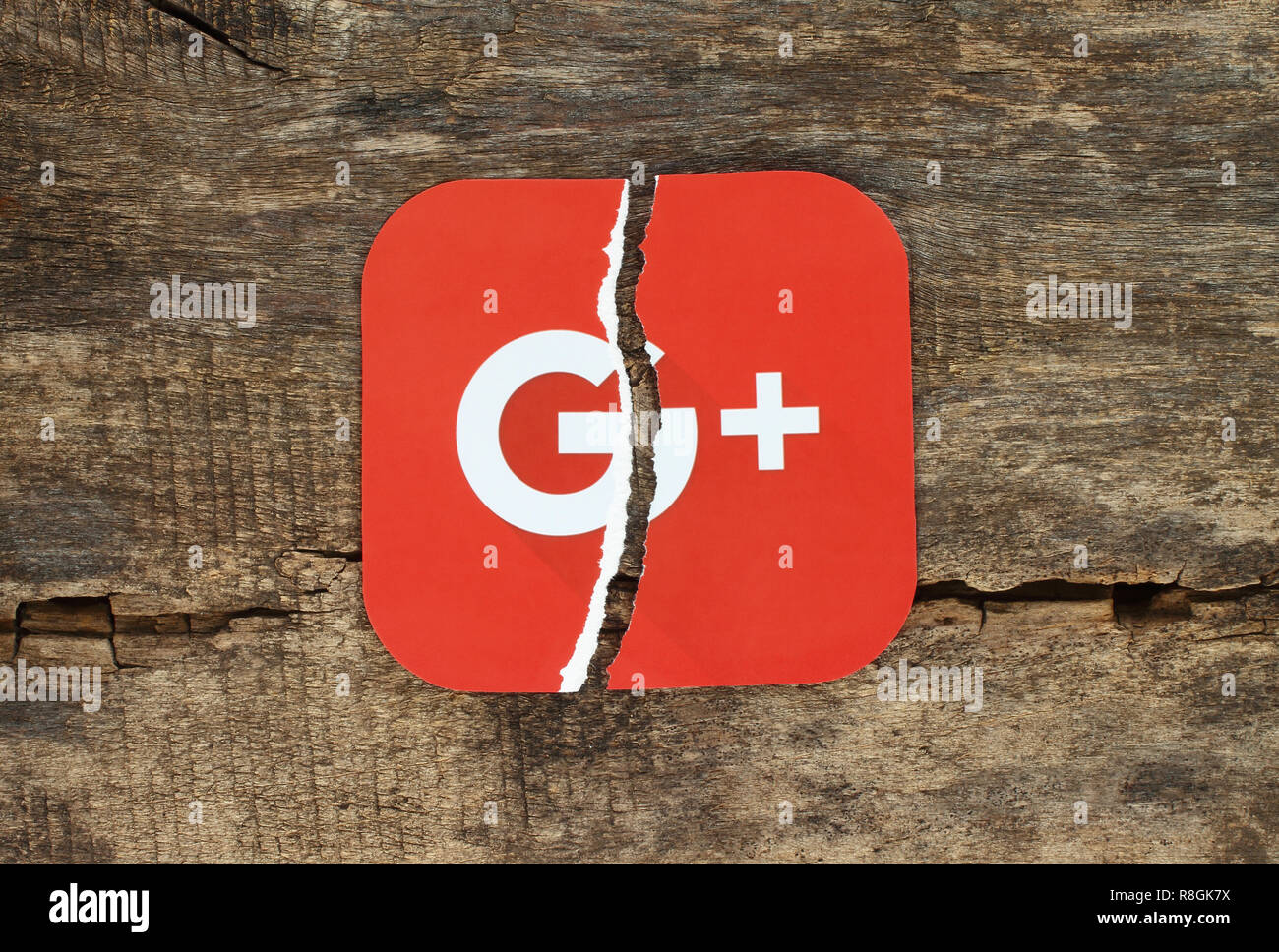 Kiew, Ukraine - November 07, 2018: Google Plus Symbol auf Papier, zerrissen und auf alten hölzernen Hintergrund gedruckt. Google wird heruntergefahren Google+. Stockfoto