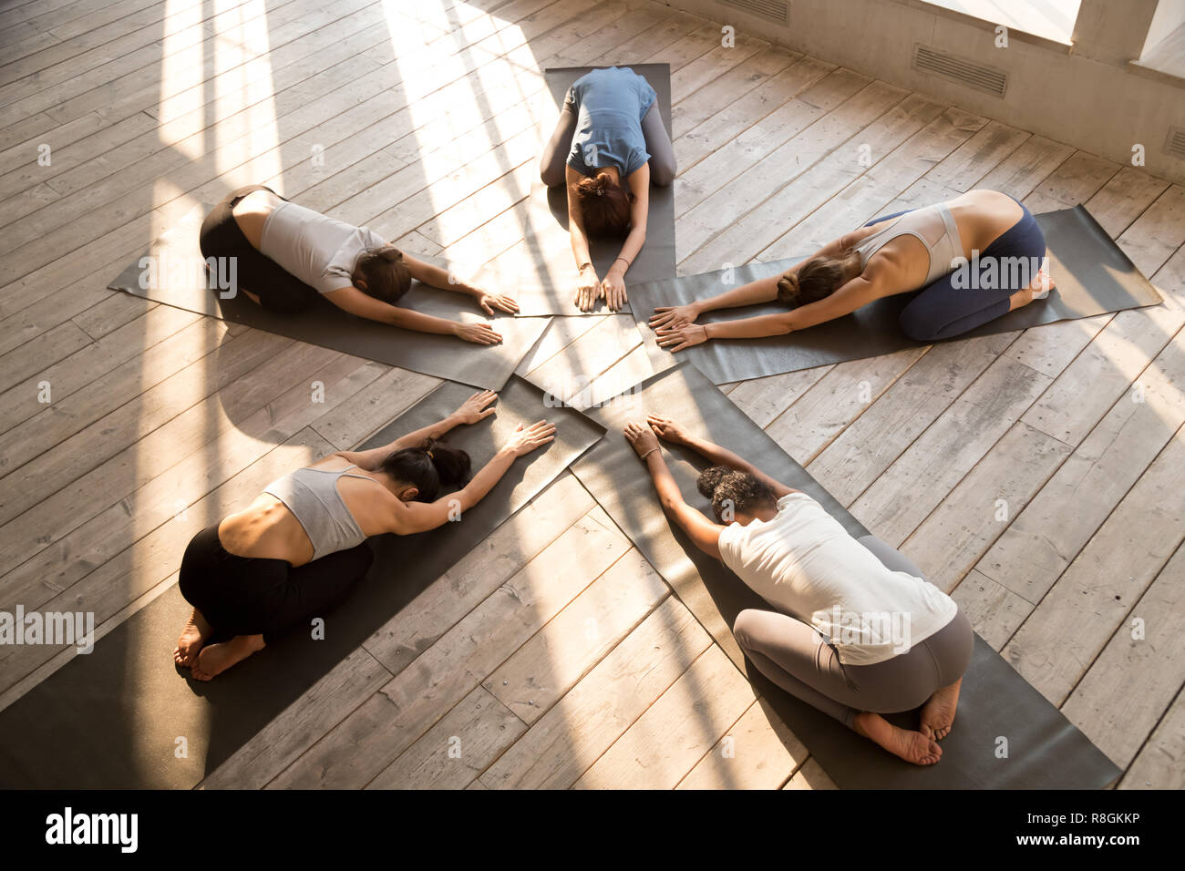Fünf junge Frauen tun Kind darstellen, während Yoga Session Stockfoto