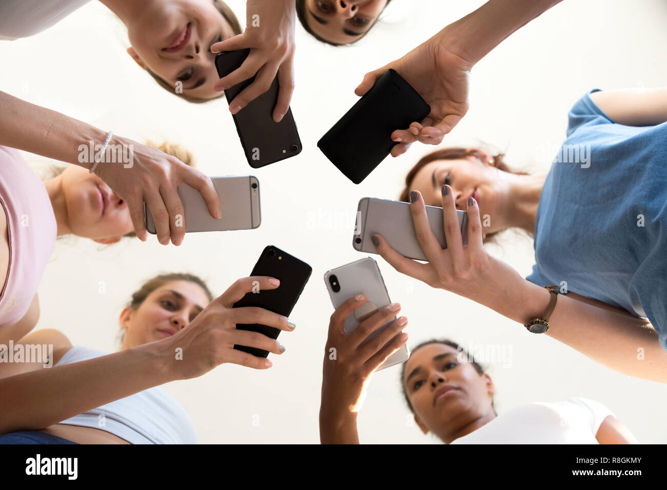 Diverse Frauen im Kreis halten smartphones Blick vom Ständigen Stockfoto