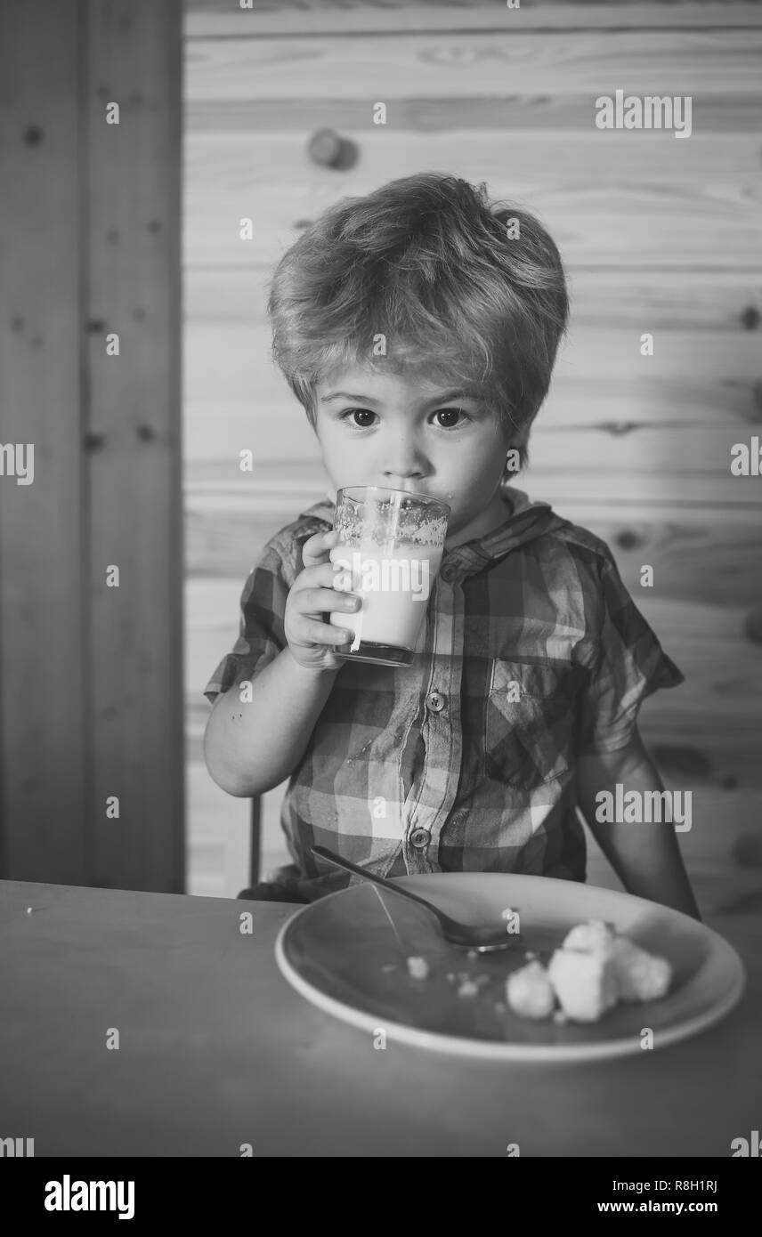 Kleine junge Kind essen Bananen und Milch trinken. Stockfoto