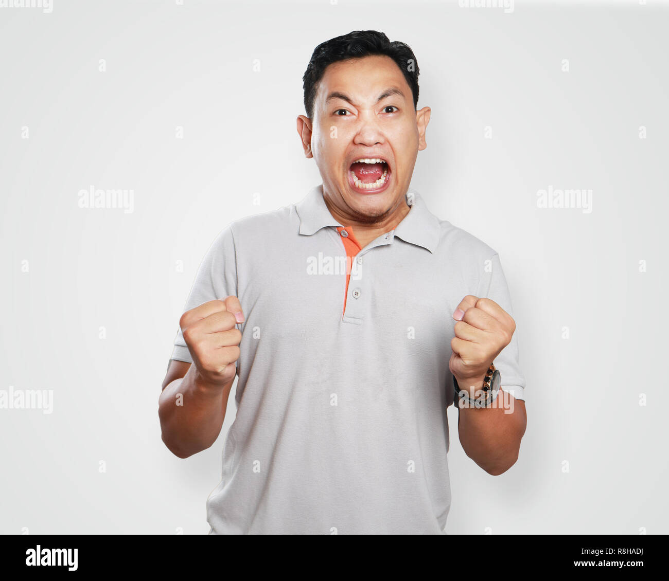 Foto Portrait von einem netten gutaussehenden jungen asiatischen Menschen schreien Zorn zu lösen, mit seinen Fäusten bereit zu lochen Stockfoto