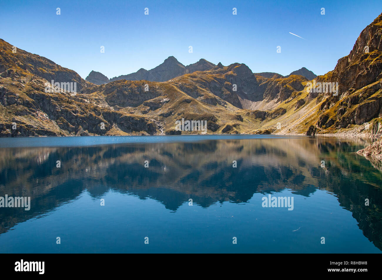 Die Berge hinter Lac d'Artouste in den französischen Pyrenäen sind im Wasser des Sees auf einem noch und klaren Herbsttag wider Stockfoto