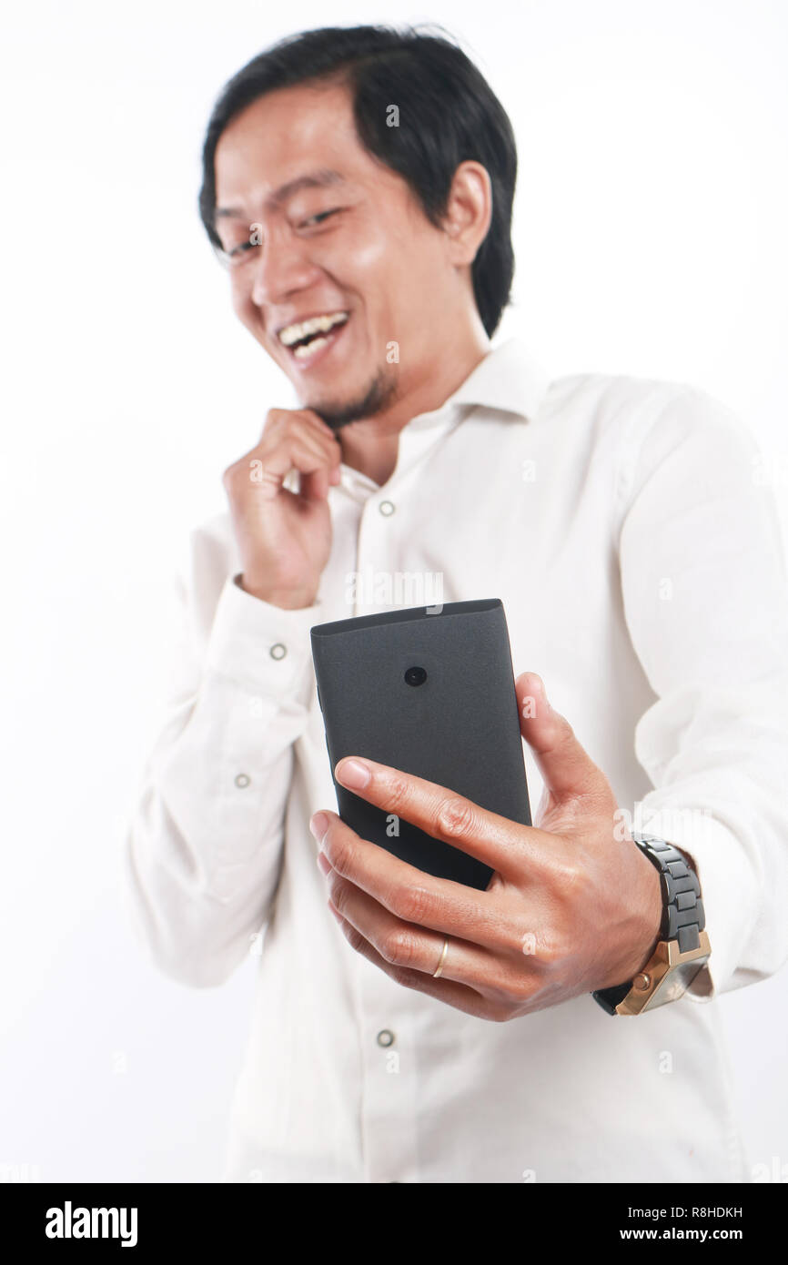 Foto Bild Portrait einer Lustig junge asiatische Geschäftsmann sah glücklich und lächelnd während der Einnahme von selfie Foto von selbst auf seinem Smartphone, bis por schließen Stockfoto