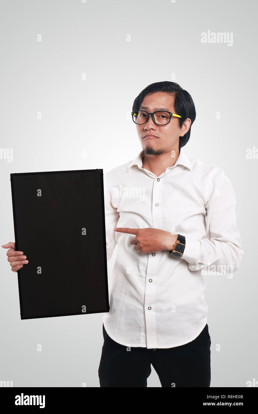 Foto Portrait von lustigen Asiatische Geschäftsmann oder Lehrer oder Schüler zeigen leere Tafel mit traurigem Gesicht, Tafel halten mit einer Hand, während die o Stockfoto