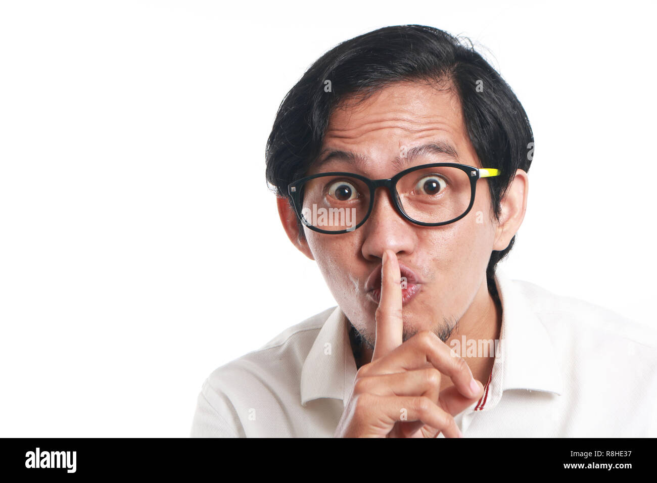 Foto Bild Portrait einer Lustig junge asiatische Geschäftsmann Brille mit ssh anmelden, Nahaufnahme, Porträt mit einem Finger auf die Lippen, zum Schweigen zu bringen. Stockfoto