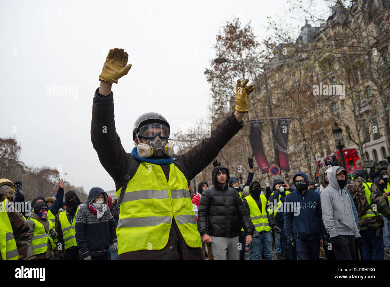 Champs Elysées, Paris, Frankreich. 15. Dez 2018. Demonstrant tragen Gasmaske hebt seine Hände die Polizei. Gelb (gilets Jaunes) Proteste, Champs-Elysées, Paris, Frankreich, 15. Dezember 2018. Credit: Julien Garnier/Alamy leben Nachrichten Stockfoto