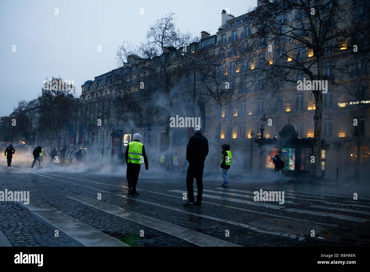 Paris, Frankreich. 15. Dezember 2018. Die Bereitschaftspolizei verwendet eine Wasser canon und Gas gegen Demonstranten während eines Protestes gegen die steigende der Treibstoff- und Ölpreise durch Menschen tragen gelbe Westen reißen. Credit: ALEXANDROS MICHAILIDIS/Alamy leben Nachrichten Stockfoto
