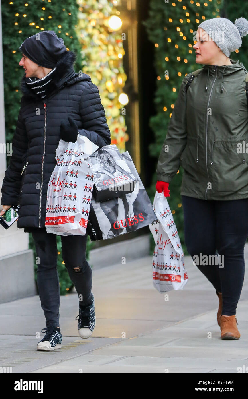 Weihnachten Shopper sind mit Hamleys Taschen an der Londoner Oxford Street mit 9 Tage zu Weihnachten gesehen. Händler rechnen mit einem Ansturm der Käufer in der Leitung - bis zu Weihnachten. Stockfoto