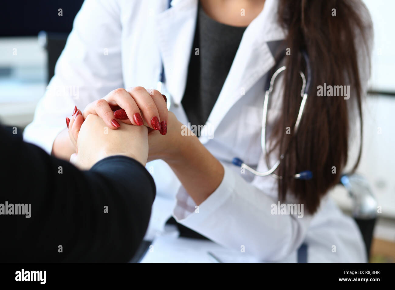 Junge Ärztin hält kranken Patienten von Hand Stockfoto