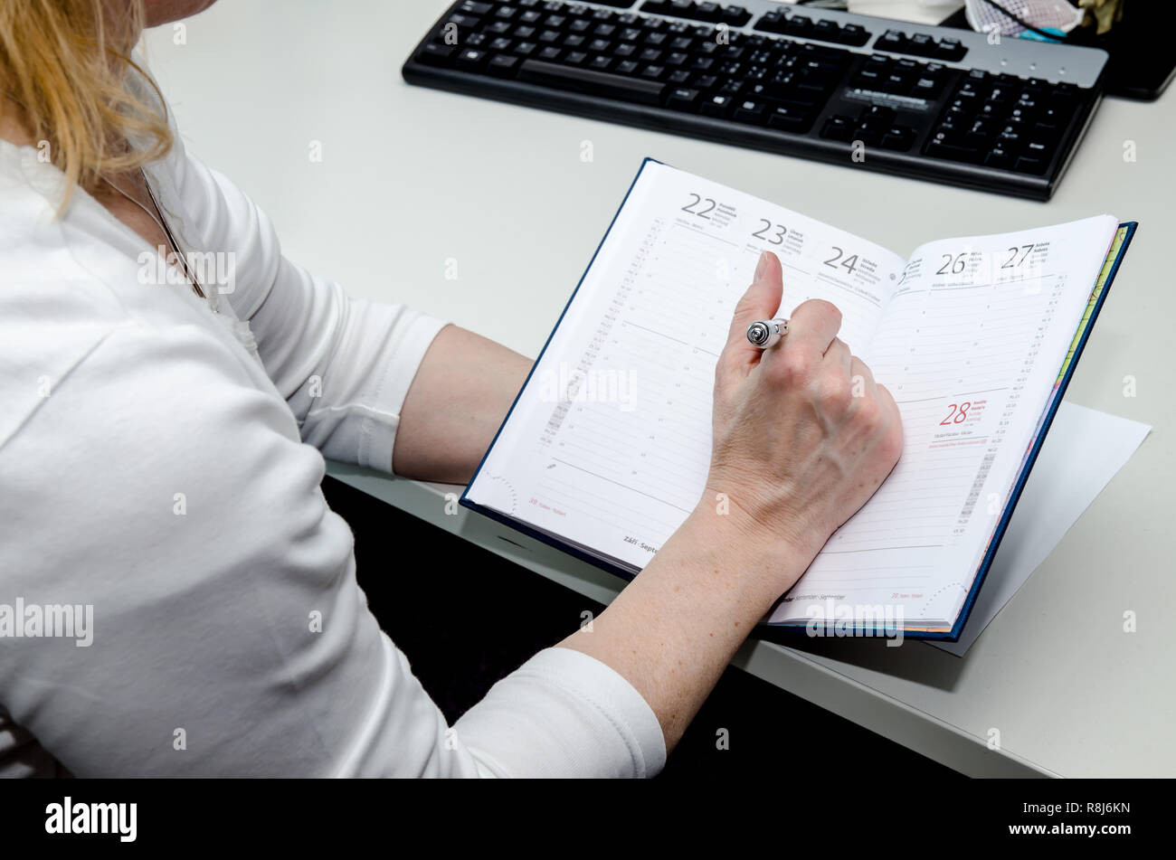 Hand Notizen in Weiß Tagebuch auf dem Tisch Stockfoto