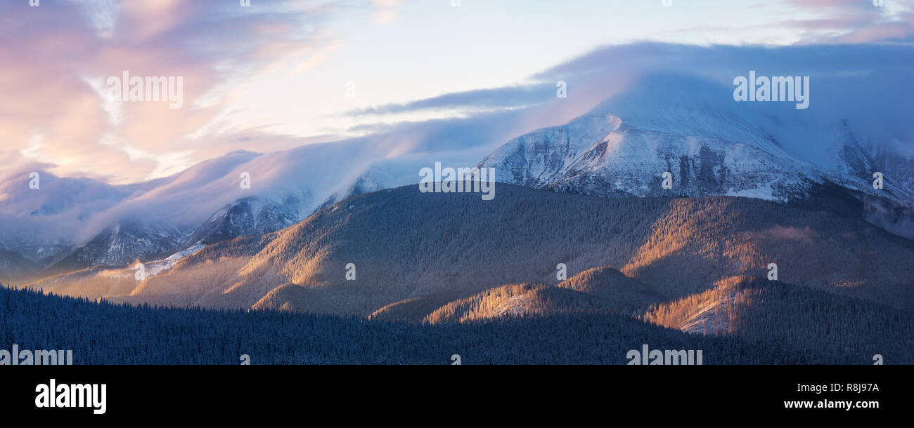 Bergpanorama mit schönen Wolken und den Sonnenuntergang. Winterlandschaft mit einem Spitzenwert Stockfoto