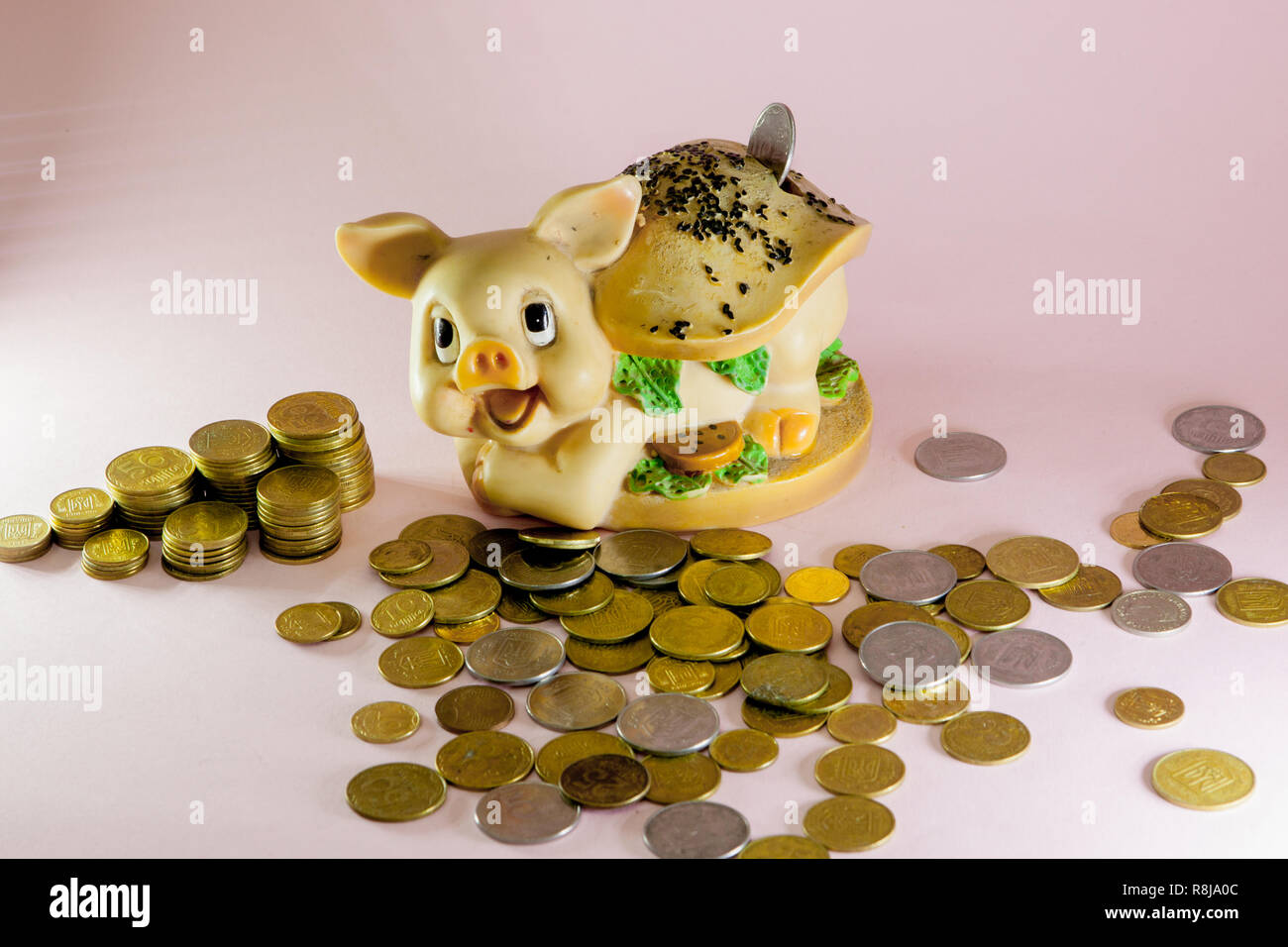 Sparschwein mit Münze auf rosa Hintergrund Stockfoto