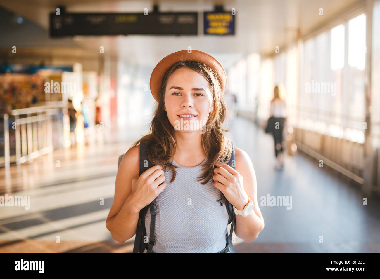 Thema Tourismus reisen. Junge schöne kaukasische Frau in kleid und hut mit Rucksack touristische Mat im Terminal Station in einem langen Gang, der plan b Stockfoto