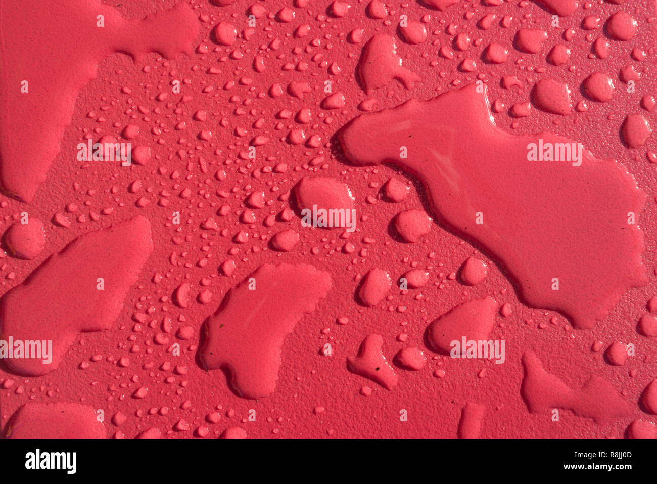 Mehrere Wasser Tropfen Regentropfen auf rotem Hintergrund Stockfoto