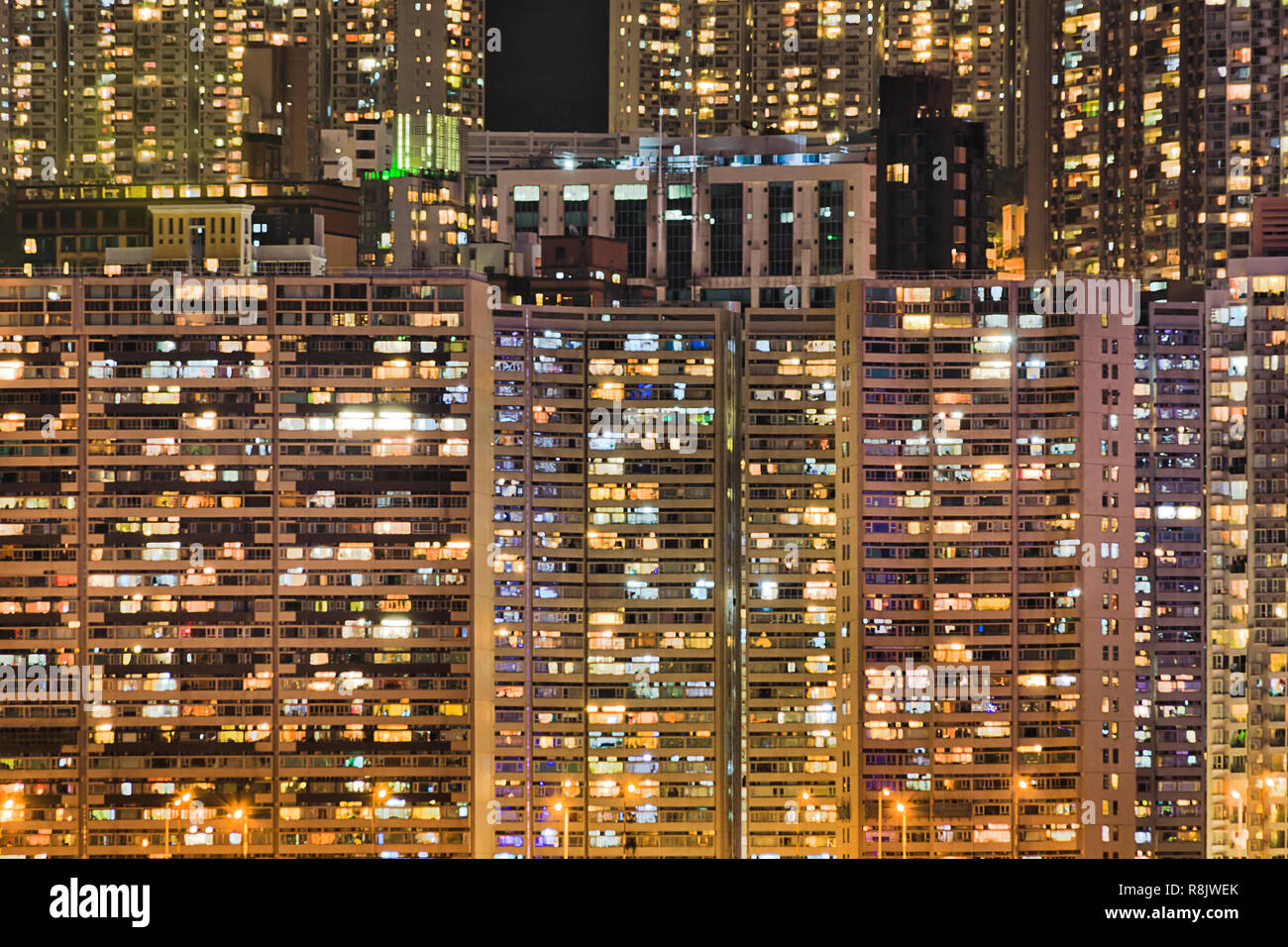 Dicht besiedelten Skyscraper wohn Türme von Häuser in Hong Kong bei Nacht mit helle Beleuchtung von Windows auf der Insel direkt am Wasser. Stockfoto