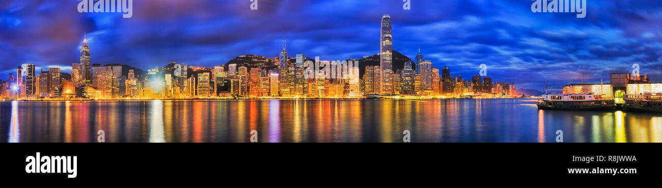 Breites Panorama der Insel Hong Kong City CBD Waterfront mit helle Beleuchtung reflektieren, Victoria Harbour Gewässer bei Sonnenaufgang. Stockfoto