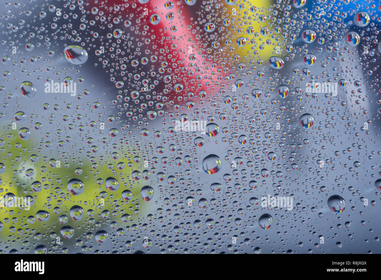 Wassertropfen, Regentropfen oder Tröpfchen auf Glas mit push Pins im Hintergrund an regnerischen Tagen. Stockfoto