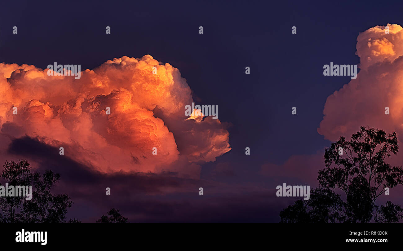Orange glühen von massiven Gewitter Wolken bei Sonnenuntergang in einer Landschaft Panoramablick Stockfoto