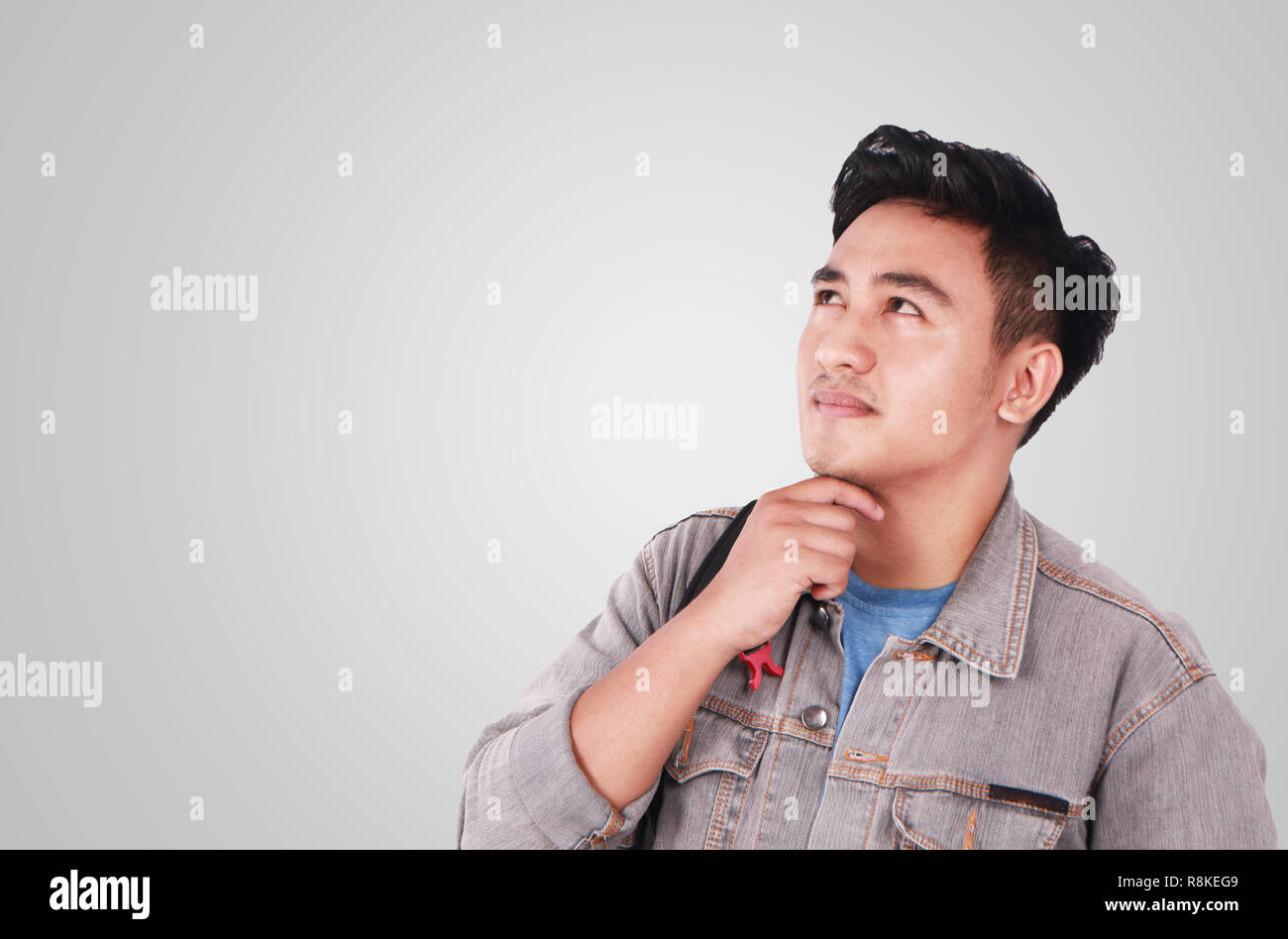 Foto Bild Portrait einer netten jungen asiatischen männlicher Student und habe nach oben geschaut und Denken Stockfoto