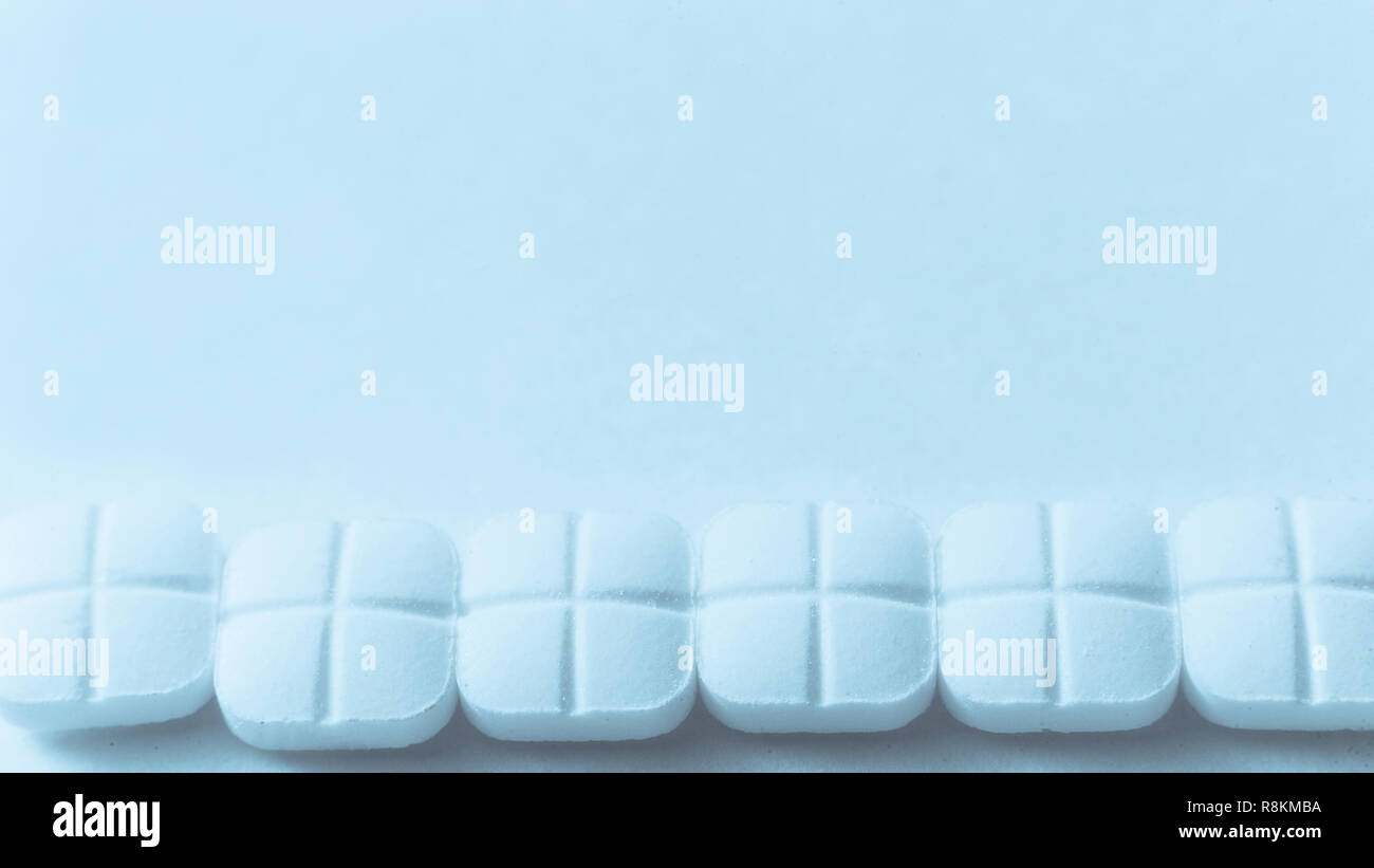 Blick von oben auf die Verschüttete weiße Pillen auf der blauen Fläche Stockfoto