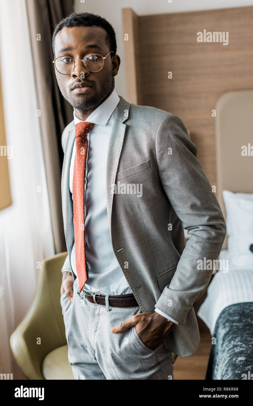 Gut aussehender Geschäftsmann in grauen Anzug und roter Krawatte im Hotel  Zimmer posing Stockfotografie - Alamy