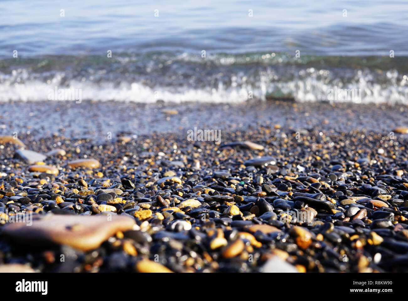 An der Küste gibt es viele kleine Steine in verschiedenen Formen. Meer surfen und Wellen hinter Meer Kiesel sichtbar. Im Fernen Osten Russlands, Wladiwostok Stockfoto