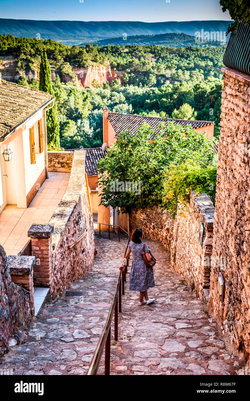 Ansicht in einer Gasse in Roussillon Frankreich mit einer Dame bewundern die schöne Ockerfarben und Landschaft der Provence in der Ferne. Stockfoto