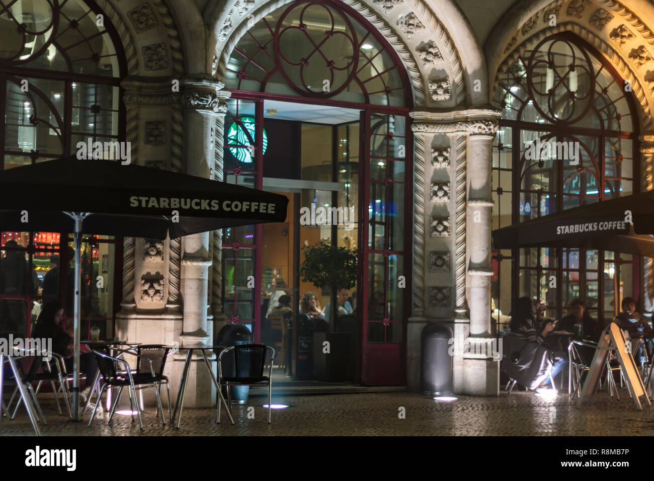 Lissabon, Portugal - ca. Dezember 2018: Starbucks Kaffee Außenfassade bei Nacht Stockfoto