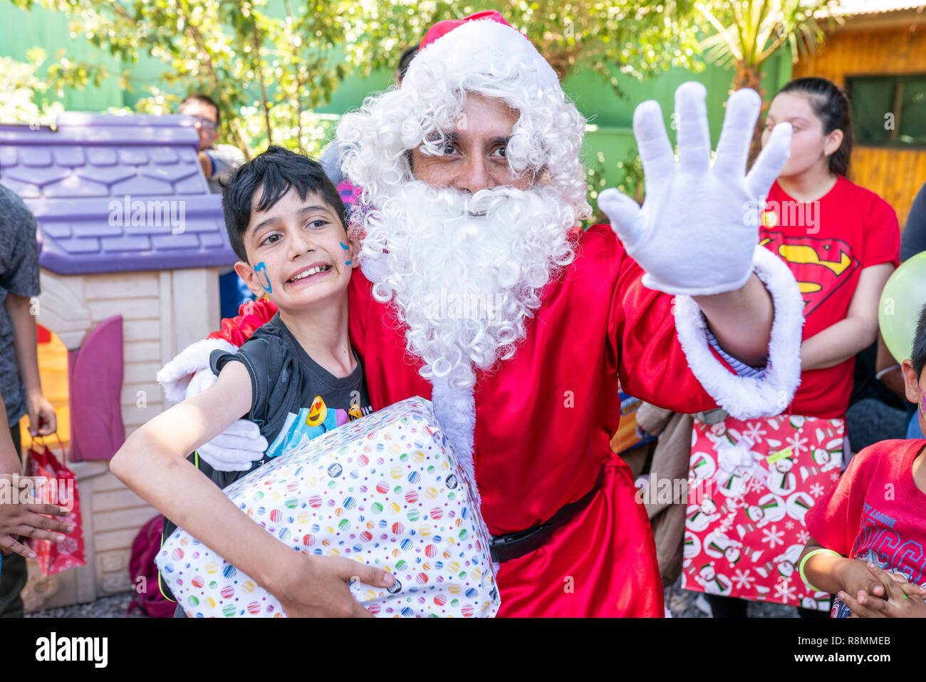 Santa Claus Geschenke geben während Weihnachten für die Kinder der Pudahuel Norte spezielle Schule, unglaubliches Glück Gesichter, Emotionen und Wunschdenken thinkings Stockfoto