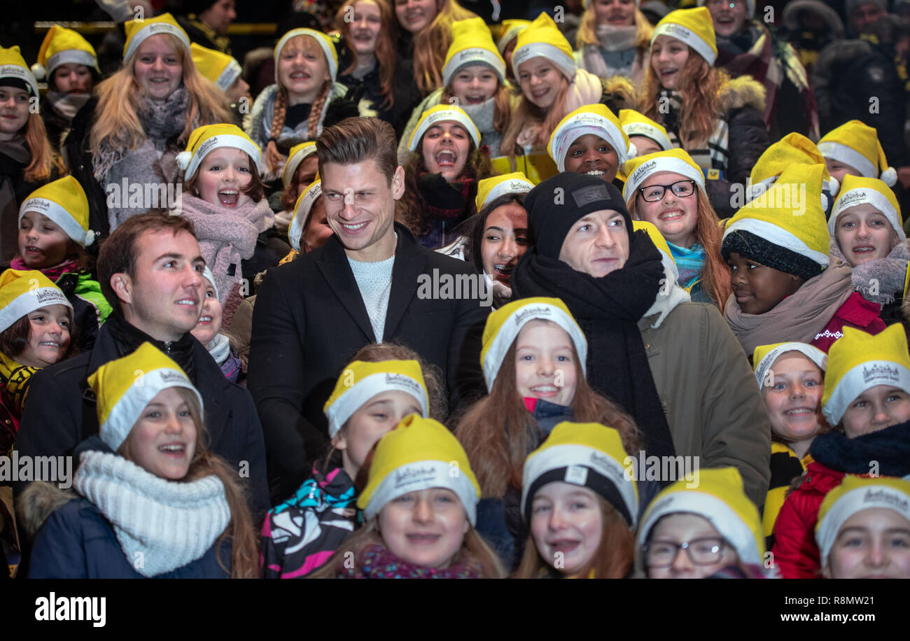 Dortmund, Deutschland. 16 Dez, 2018. Die BVB-Spieler Mario Götze, Lukasz Piszczek und Marco Reus (L-R) stehen zwischen den Mitgliedern des WDR Kinder Chor des Dortmunder Chor Akademie an, was nach Ansicht der Organisatoren ist Deutschlands größtes Weihnachtslied im Signal Iduna Park. 50.000 Sänger wurden in der BVB Stadion erwartet. Quelle: Bernd Thissen/dpa/Alamy leben Nachrichten Stockfoto