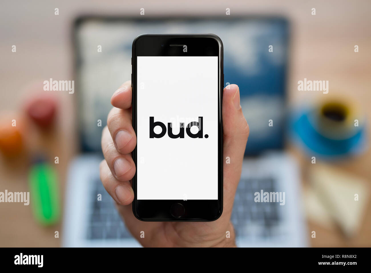 Ein Mann schaut auf seinem iPhone die zeigt die Bud. Logo (nur redaktionelle Nutzung). Stockfoto