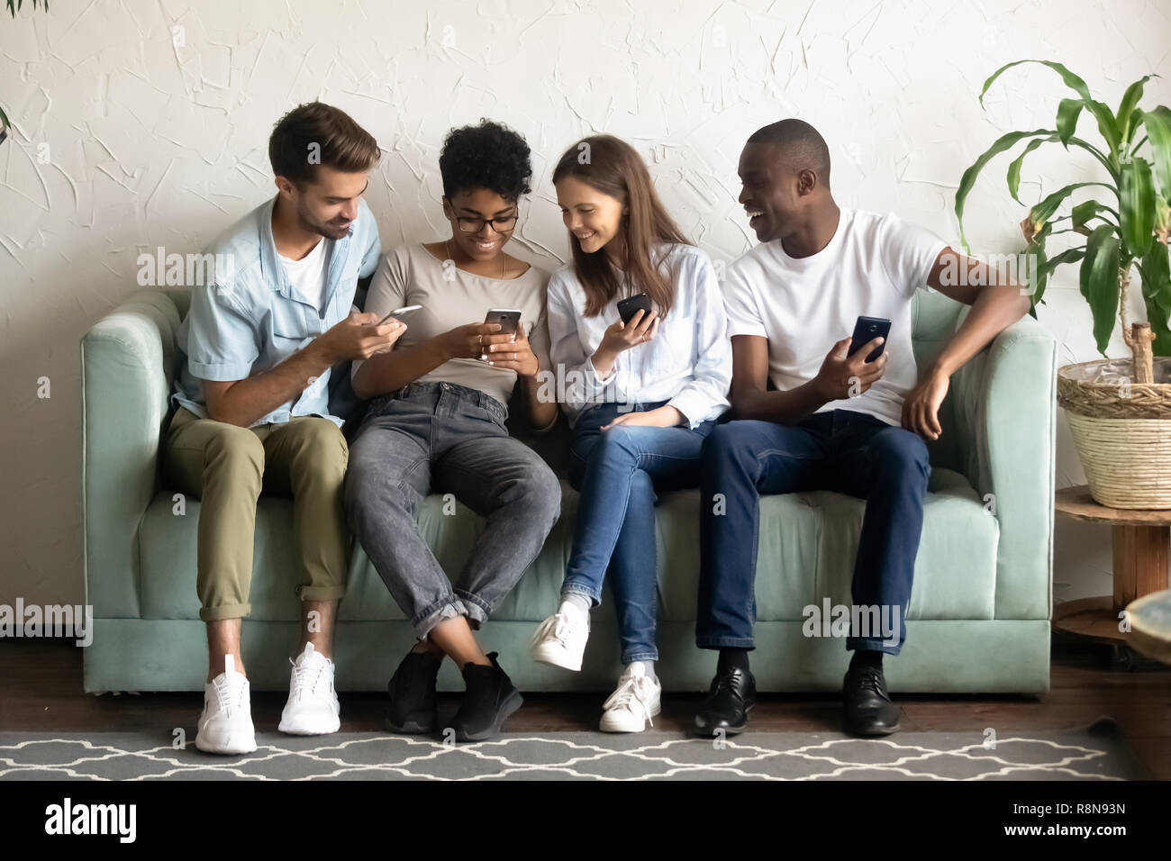 Lächelnd afrikanische amerikanische Frau zeigen Witz am Telefon zu diversen Fri Stockfoto