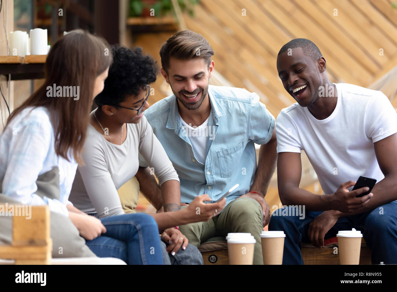 Afrikanische amerikanische Frau zeigen zu lachen Freunde lustige Nachrichten Stockfoto