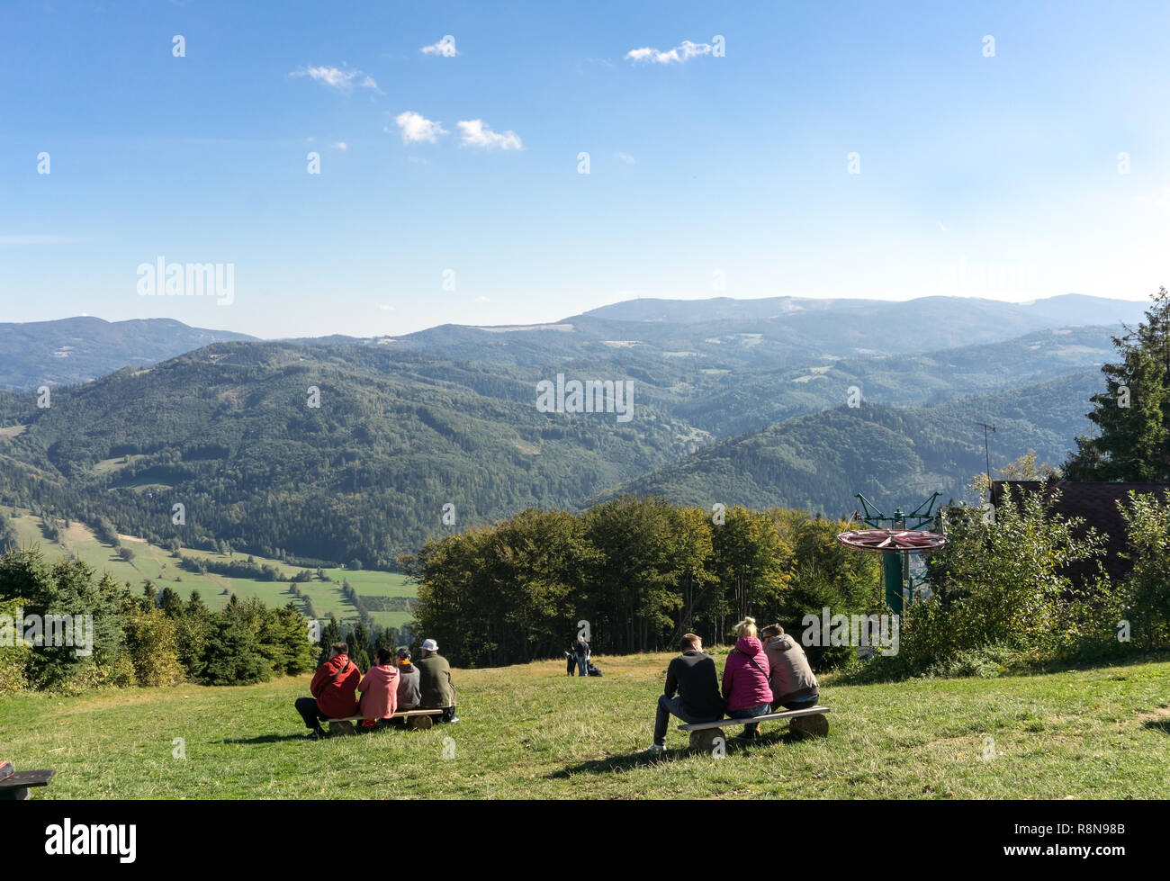 Berg Czantoria, Schlesische Beskiden, Polen. Menschen ruhen auf einer Bank in den Bergen auf einem sonnigen outumn Tag. Stockfoto