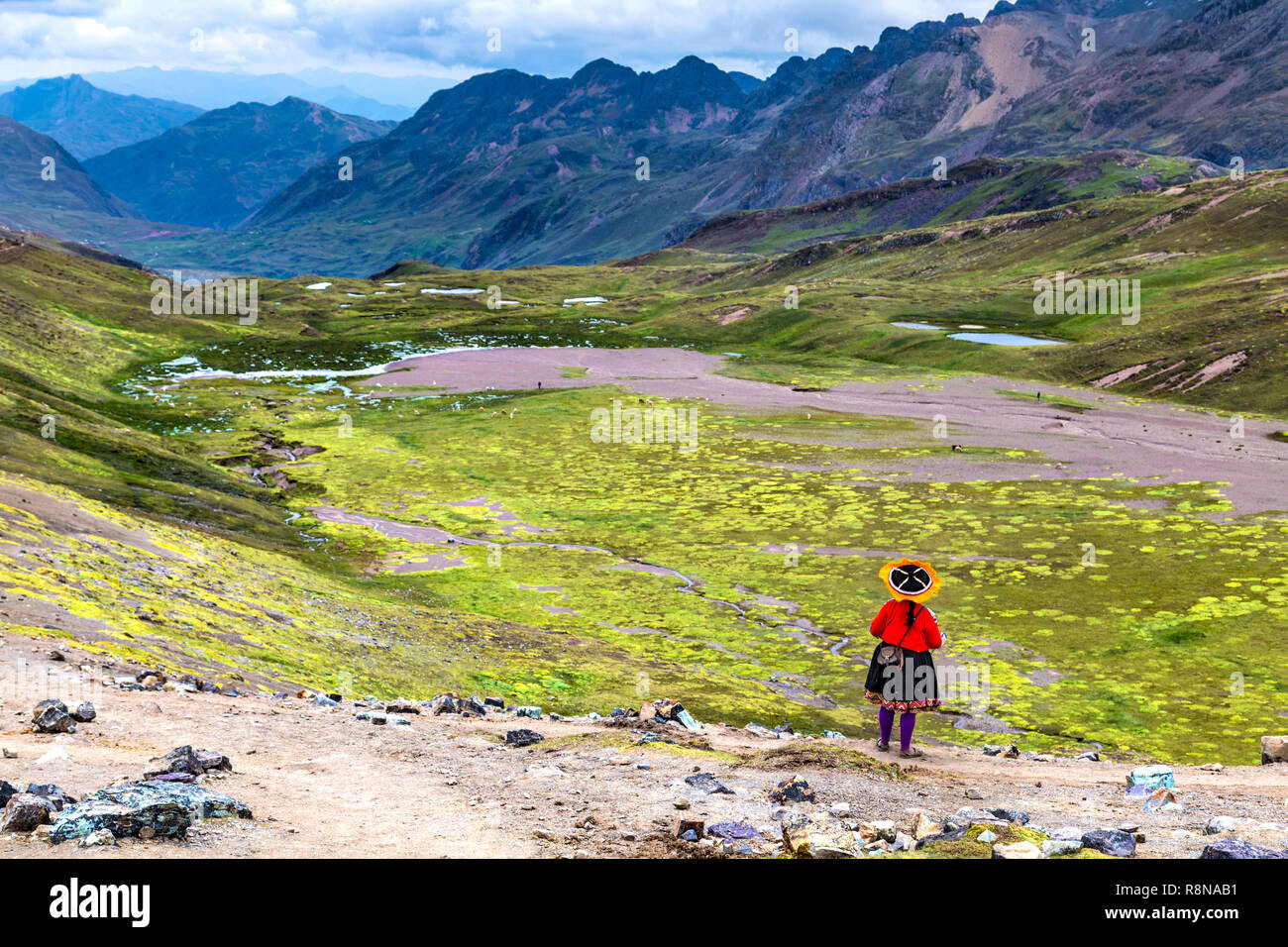 Peruanische Frau in traditioneller Kleidung über eine malerische Landschaft in den Anden rund um Ausangate und Rainbow Bergen (Vinicunca), Peru suchen Stockfoto