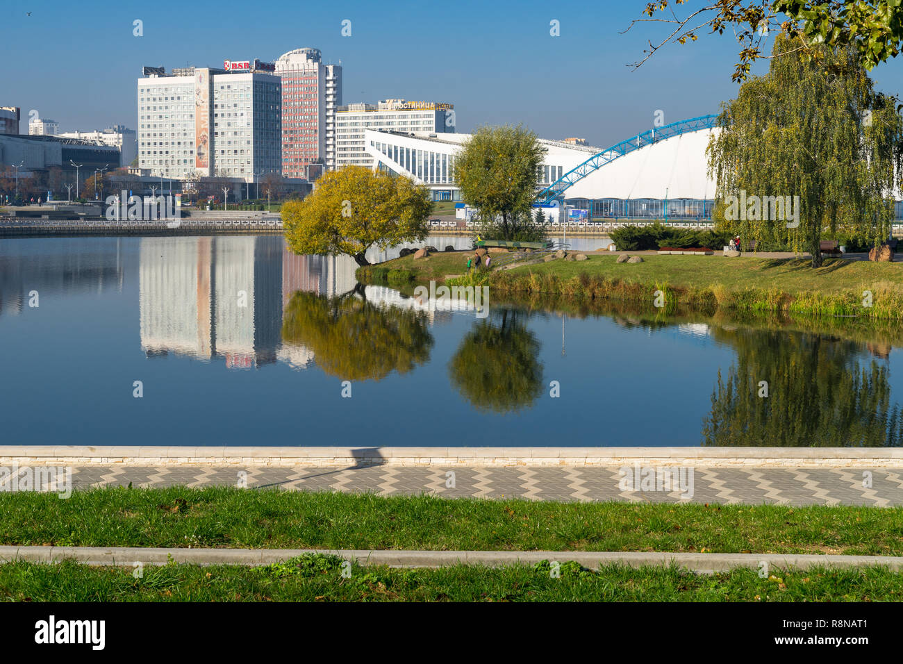 Ansicht mit Wasser Reflexionen in swislotsch Fluss - saisonale Eisbahn in der Traglufthalle, Minsk Sport Palast und mehrstöckige Häuser Stockfoto