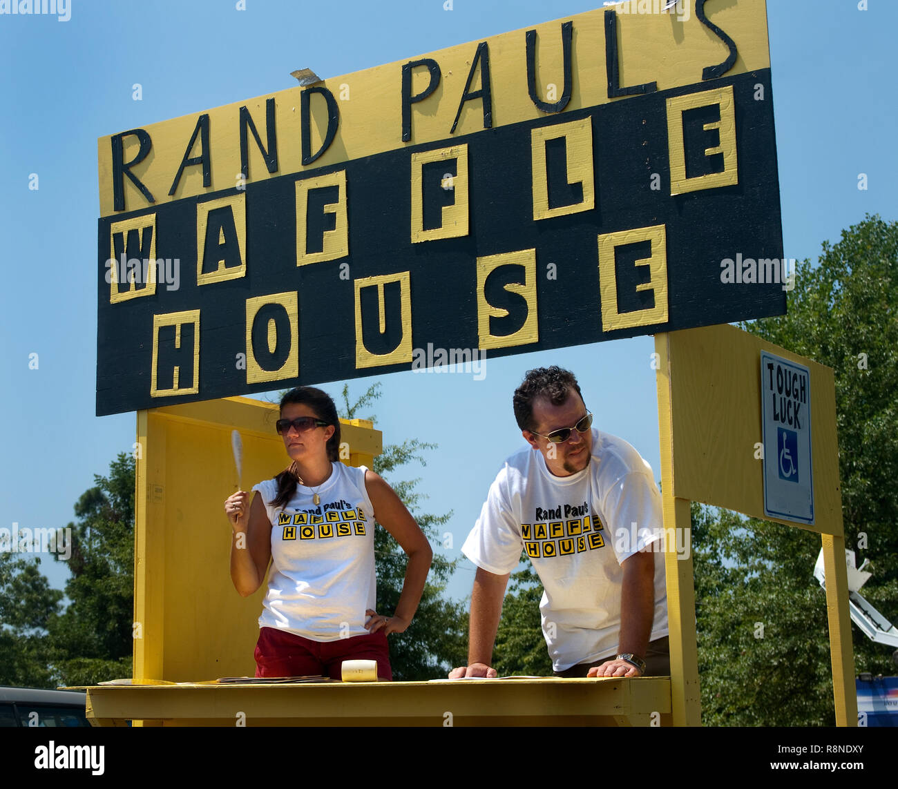 Susy Evans und Dan Robinette verteilen mock Menüs kritisieren republikanischen Senat Kandidat Paul Rand an der Fance Farm Picknick in Fancy Farm, Kentucky. Stockfoto
