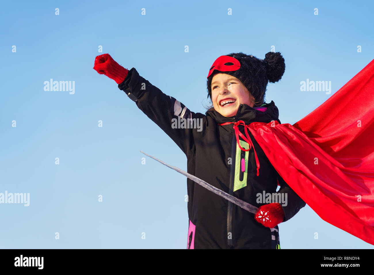 Lustiges kleines Mädchen macht super-Helden zu spielen. Stockfoto